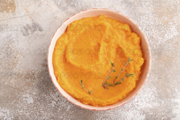 Sweet potato porridge in ceramic bowl on brown concrete background. Diet, healthy eating concept.