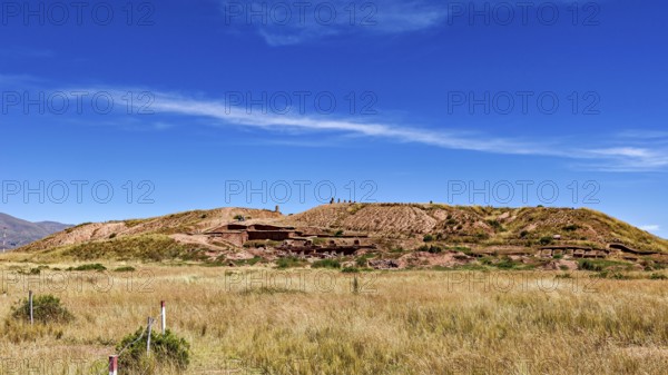 Meadow hill with traces of ruins, under wide blue skies, highlights the natural beauty of the