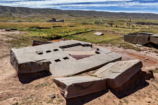 Large stone blocks and ruin structures on dry soil under a far-reaching sky, the archaeological