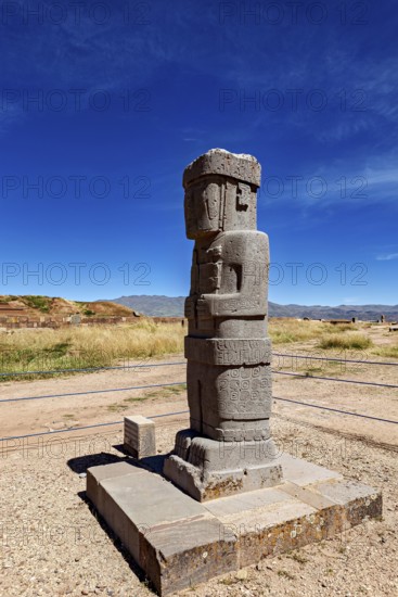 Ancient stone figure standing upright on a platform against a clear sky, the archaeological site