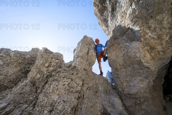Mountaineers between rocks on the Via Ferrata Bocciere Centrale Via Ferrata, Sun Star, Brenta