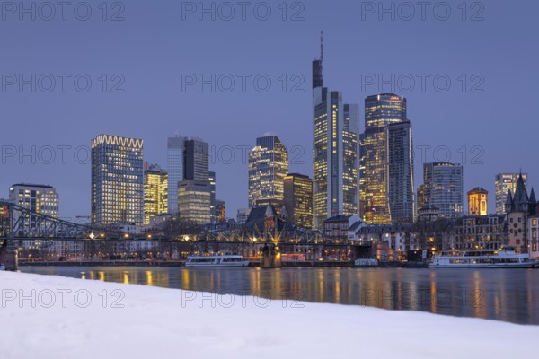 The towers of the Frankfurt banking skyline rise behind the snow-covered banks of the Main,