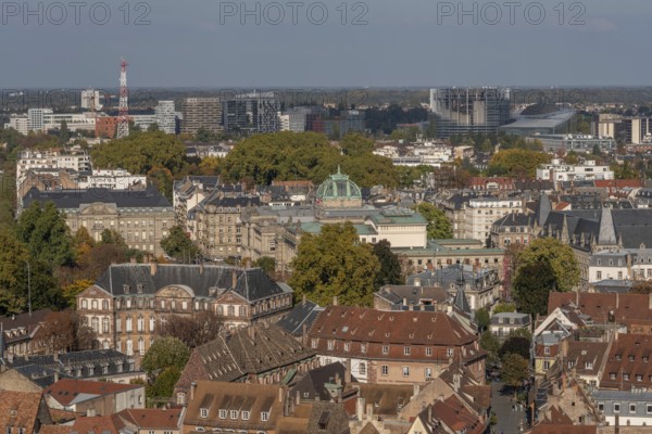 The stone balcony offers a view of the city of Strasbourg. Houses and buildings can be seen under a