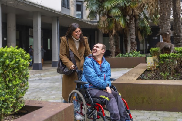 Smiling caregiver pushing wheelchair, sharing warm conversation and laughter with happy man