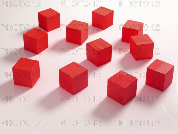 11 red wooden cubes against a white background