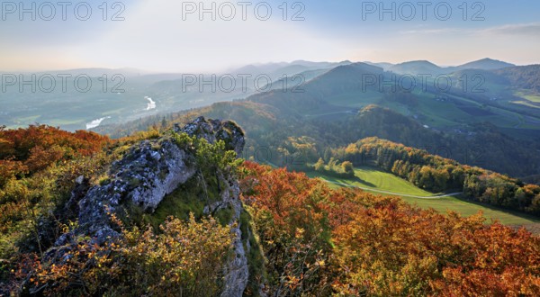 View of an autumnal forest from the Gisliflue, behind the Jura foothills with Wasserfluh and
