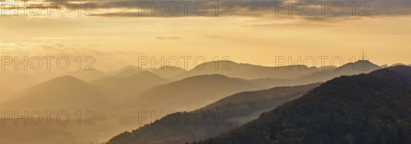 View of an autumnal forest from the Gisliflue, behind the Jurassic foothills with the water fluh in