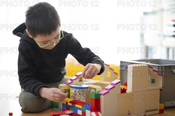 Boy, 6 years, glasses, multi-ethnic, plays with Lego, concentrates, constructs, builds, Stuttgart,