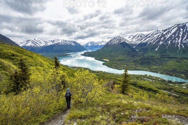 Climbers on a hiking trail, Slaughter Ridge Trail, view of snowy mountains in spring and turquoise
