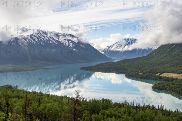 View of snowy mountains in spring and turquoise Kenai Lake with reflection, Slaughter Ridge Trail,