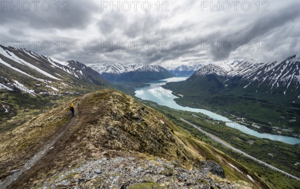 Climbers on a hiking trail on Slaughter Ridge, views of snowy mountains in spring and turquoise