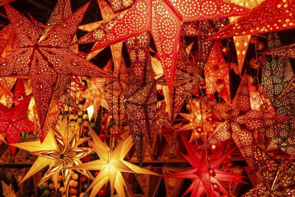 December 22, 2025, many glowing Christmas stars hanging at a market stall near St. Paul's Church,