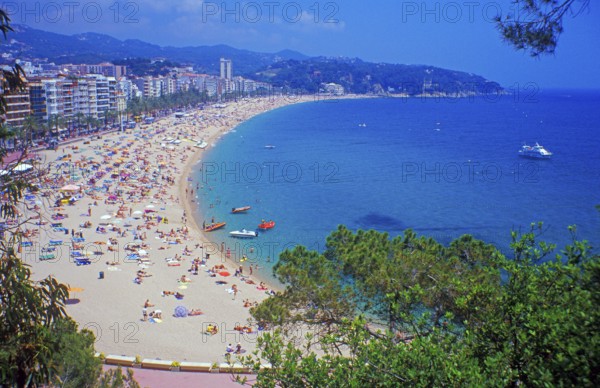 Skyscrapers, people, boats, trees, Lloret de Mar beach on the Costa de Maresme near Barcelona,