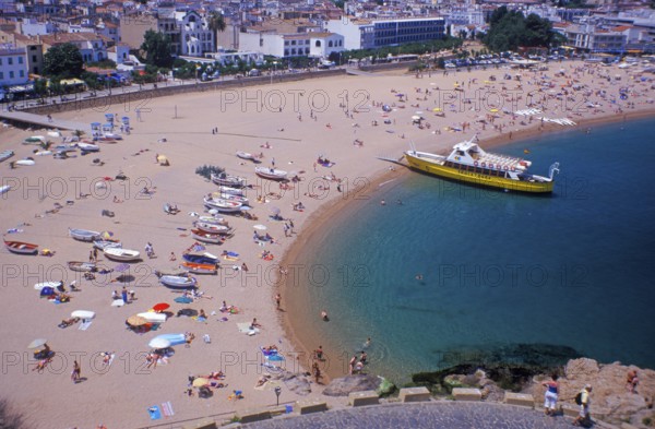 Houses, people, sightseeing boat on Tossa de Mar beach, Costa Brava, Spain, June 1999, vintage,