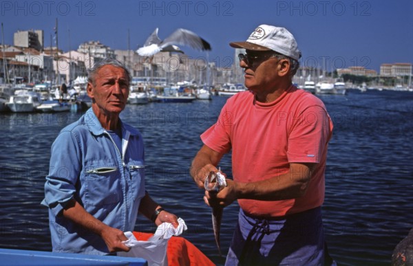 Fish seller, seagull in flight, fish market, Vieux Port, Marseille, southern France, June 1999,
