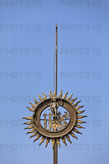 Metal sculpture with sun motif against clear blue sky, reliefs at the Basilica of St. Francis in