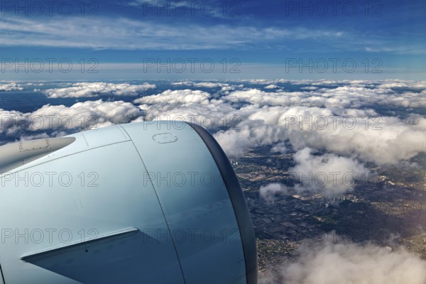 Aircraft engine above clouds overlooking the city, In an airplane above the clouds