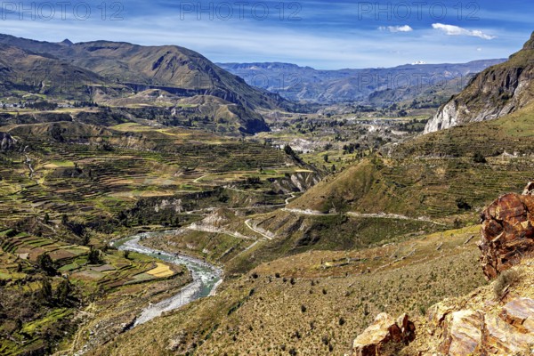 River valley with terraces and mountains under sweeping skies, the landscape of the Colca Canyon in