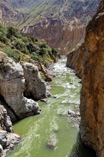 River with green water surrounded by steep rock faces, The landscape of the Colca Canyon in the