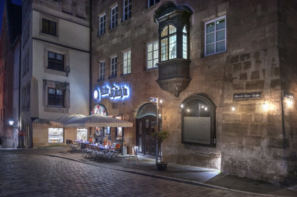 Historic restaurant, Alte Küch'n, with choirs in the evening lighting in the old town,