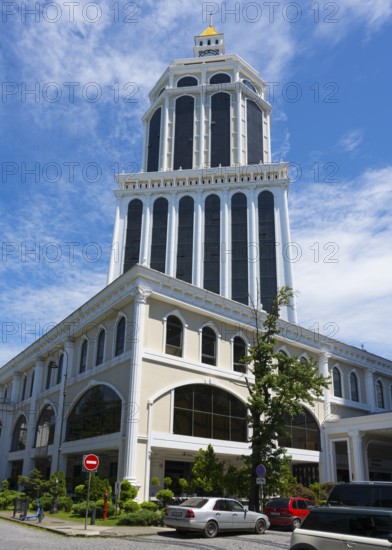 A magnificent tower of blue and white architecture rises into the sunny sky of a busy city, Hotel