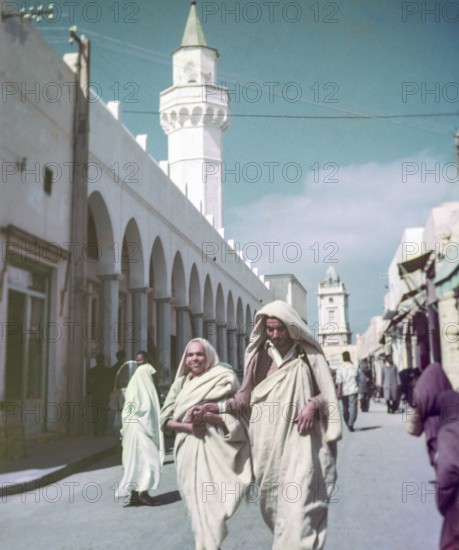 Leading blind person in street, Tripoli, Libya, North Africa 1956 minaret of Ahmed Pasha Karamanli