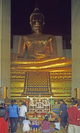 People praying in the temple with the Buddha statue Phra Mongkhonbophit, Ayutthaya, Thailand,