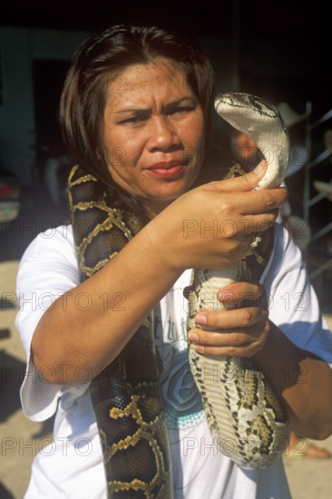 A woman presents a python in Damnoen Saduak near Bangkok, Thailand, December 2002, vintage, retro,