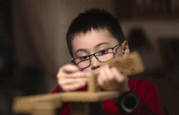 Boy, 6 years, glasses, multi-ethnic, plays concentrated, constructs, builds, Stuttgart,