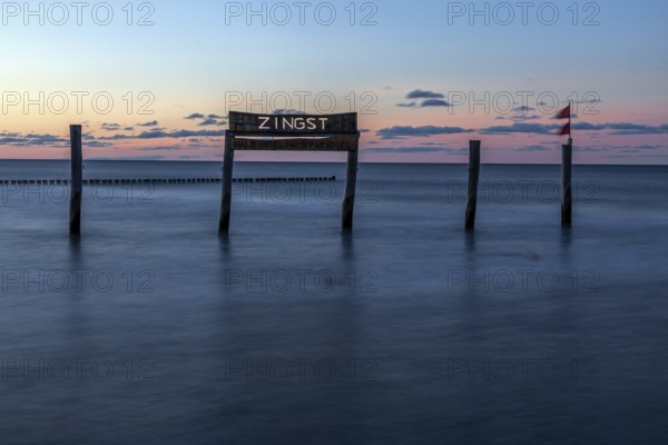 Wooden sign in the sea with inscription Zingst, long exposure, evening light, Zingst,