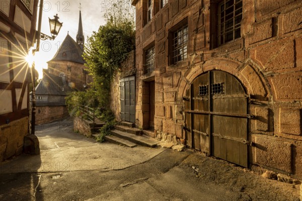 Historic alley with half-timbered houses and church in sunlight with a quiet atmosphere, The