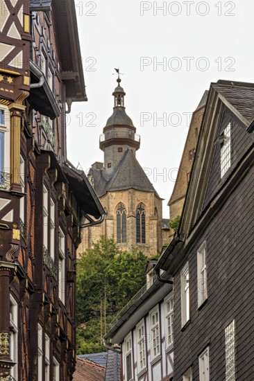 Detailed architecture shows half-timbered houses and a church above the roofs, The historic old