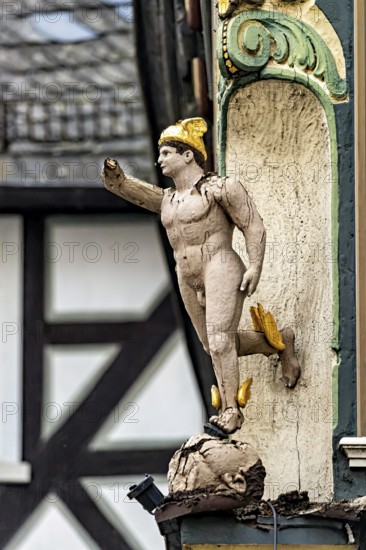An ornate wooden statue in Roman style as building decoration, gilded details, historic and
