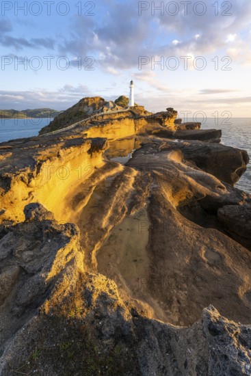 Castlepoint lighthouse on a rock, sea, sunrise. Castlepoint, Wairarapa Coast, Wellington Region,