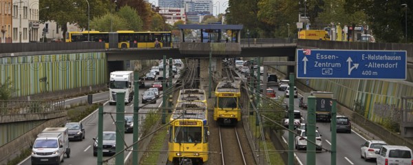 Lots of traffic on the A 40 motorway on four lanes and two subways on two lanes and a bus on the