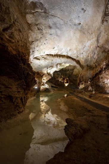 Stalactites and stalagmites, reflection in a small underground lake, rock formations in a