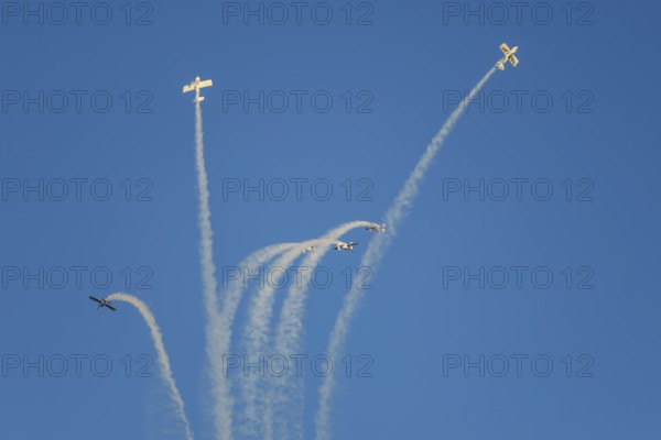 Stunt aerobatic planes performing stunts in blue sky with smoke trail. Concept of teamwork,