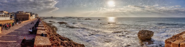 Dramatic coastline with strong waves and setting sun, Morocco, Essaouira, panorama