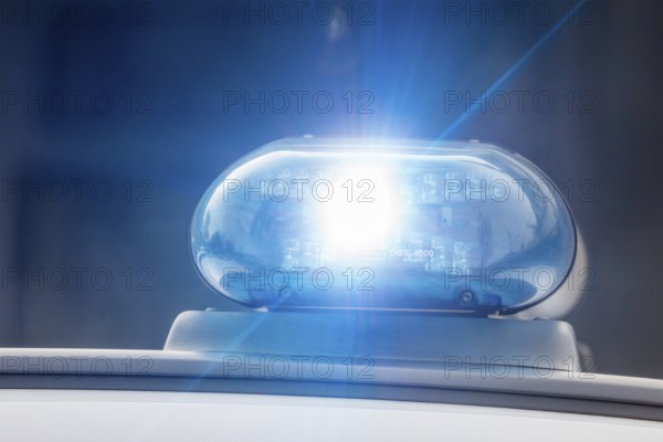 Symbolic image police operation: close-up of a blue light on a police car (digitally reworked)