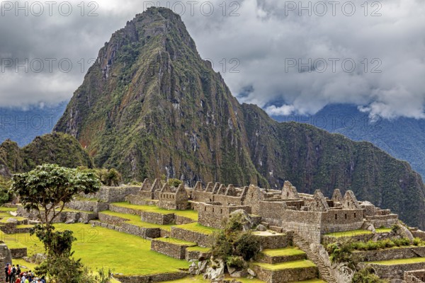 Majestic mountain behind ancient ruins under thick grass and clouds, The ruins of the Inca city of