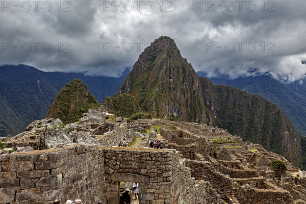Machu Picchu with dramatic cloudscape and visible mountain, The ruins of the Inca city of Machu