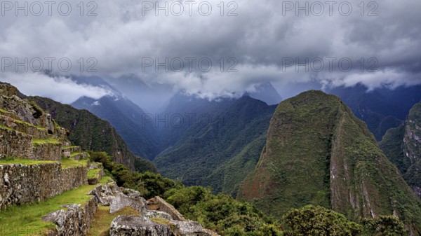 Dramatic mountain landscape with clouds and lush greenery interspersed with fog, The ruins of the