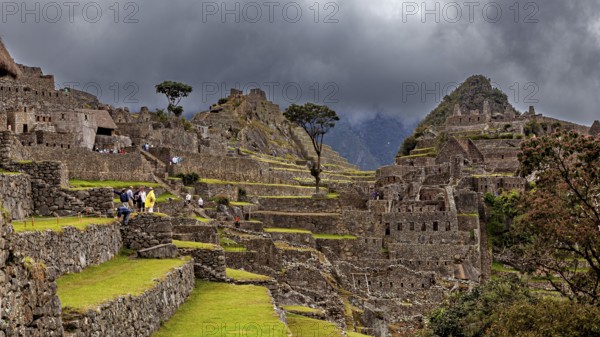 Detailed view of Machu Picchu with impressive ruins and thick cloud cover in the background, The