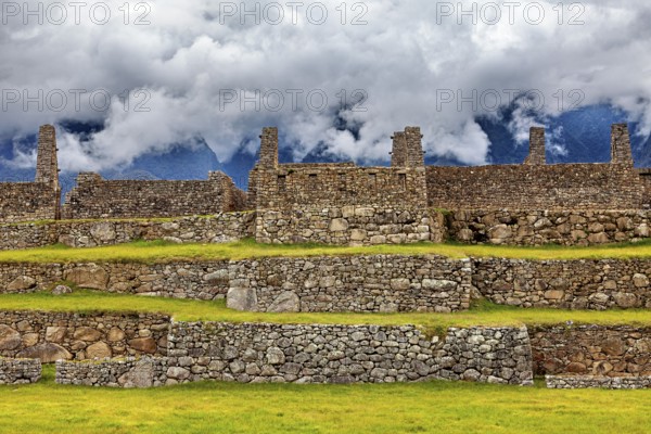 Stone ruins on several levels with mountains and clouds in the background, The ruins of the Inca