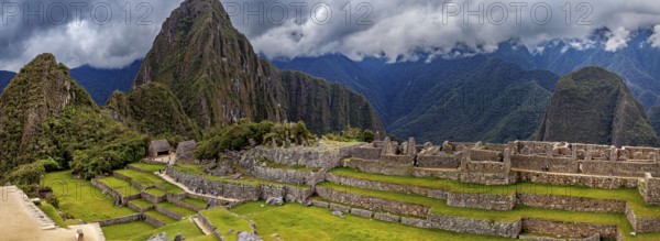 Panorama of Machu Picchu with mountains in the background and thick cloud sky, The ruins of the