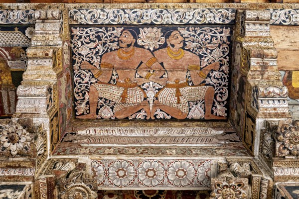 Ornate wall painting with two symmetrical warrior figures in a traditional temple, the decoration