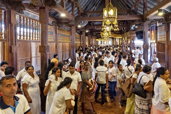 Large crowd in an interior decorated with wooden beams at a meeting, people and pilgrims in the
