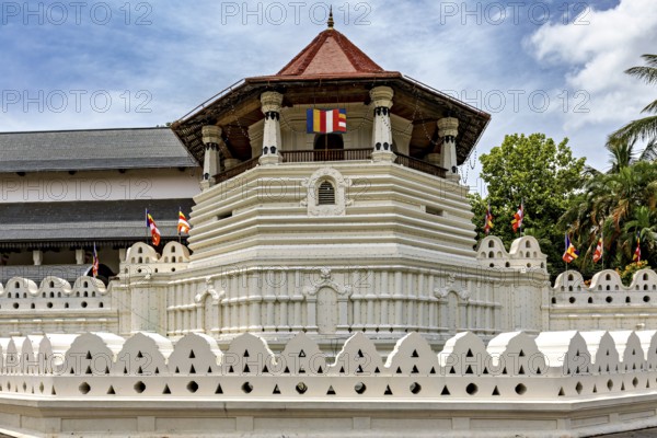Detail of a temple with pavilion, colorful flags and white walls, The Temple of the Tooth in Kandy