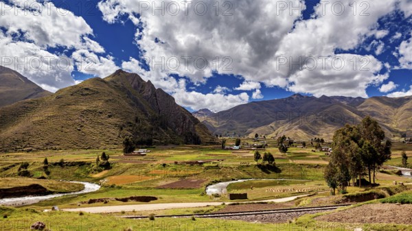 Picturesque landscape with hills, river and lush greenery under a cloudy sky, The landscape in the