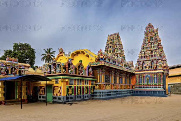 Hindu temple with colorful sculptures and traditional architecture under clear skies, The Sri
